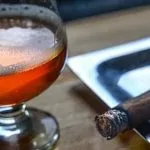 Cerveza en copa y puro encendido