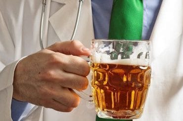 Doctor sosteniendo una cerveza