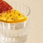 Copa de mezcal artesanal con sal de gusano y limón, la forma tradicional de servirlo en México