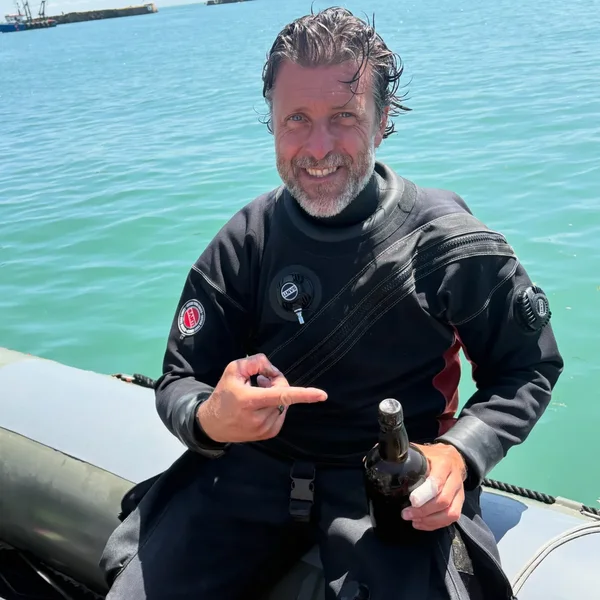 Stefan Panis con la botella de Guinness del Mindoro El buzo Stefan Panis sostiene la botella de Guinness recuperada del naufragio del Mindoro