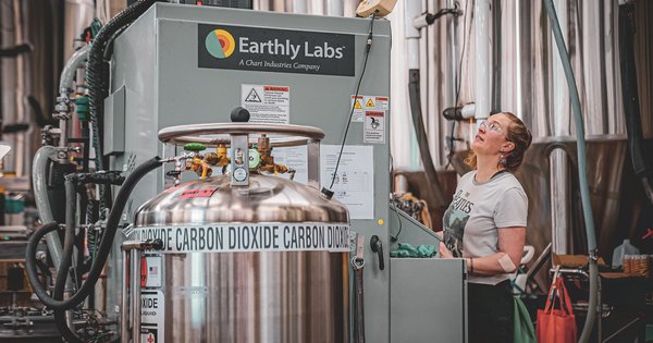 Operario ajusta una unidad de captura de CO2 Earthly Labs en una cervecería