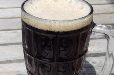 Jarra de vidrio con cerveza de raíz o root beer y espuma