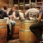 Grupo de personas conversa en la barra de un bar concurrido, escenario del efecto cóctel