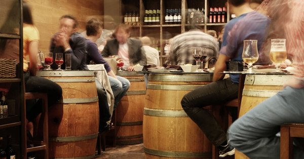Efecto cóctel en un bar concurrido Grupo de personas conversa en la barra de un bar concurrido, escenario del efecto cóctel