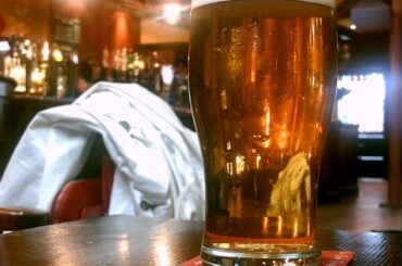 Pinta de cerveza rubia sobre una mesa de pub