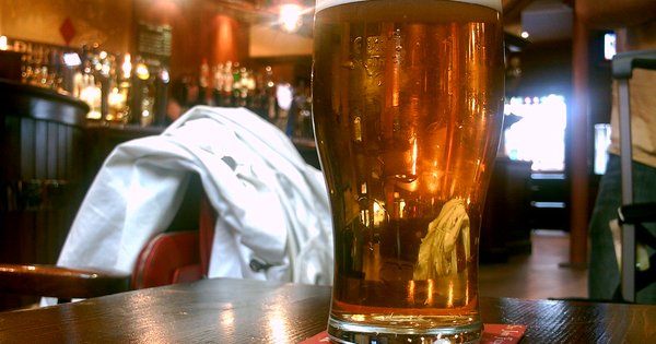Hígado graso y cerveza Pinta de cerveza rubia sobre una mesa de pub