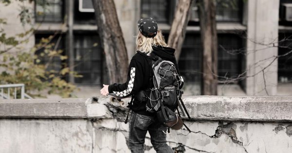 Joven con mochila caminando por la calle, el alcoholismo en adolescentes y su prevención