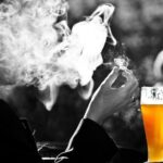 Hombre fumando mientras bebe cerveza, el consumo de alcohol y tabaco a la vez