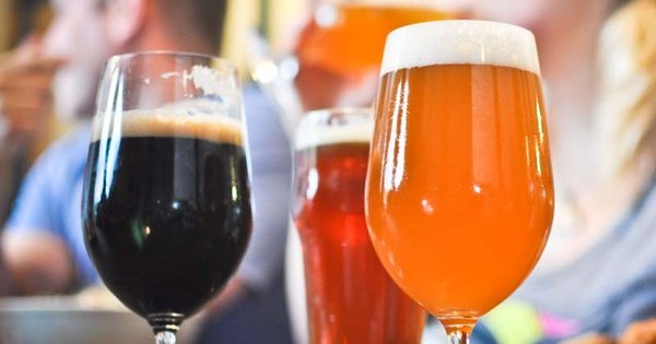 Three beers of different colors, a dark beer, a red beer and an amber beer, served on a table