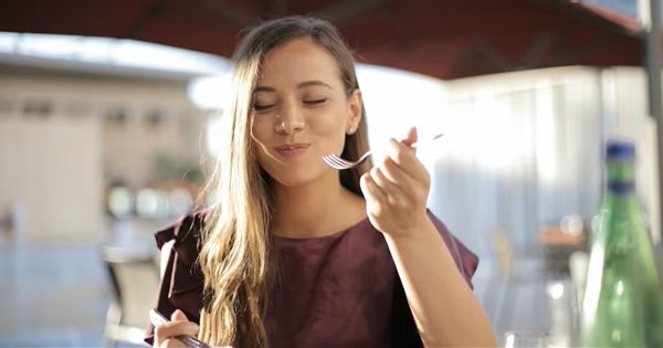 Mujer saboreando un bocado con los ojos cerrados, el kokumi y la sensación de plenitud en boca